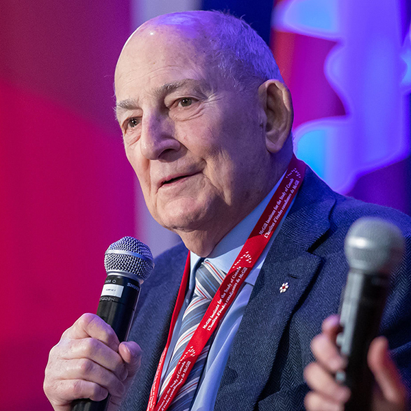 Charles Bronfman speaking into a microphone on stage