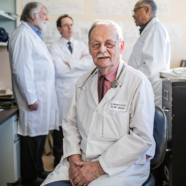 Michel Chrétien sitting in front of a group of scientists