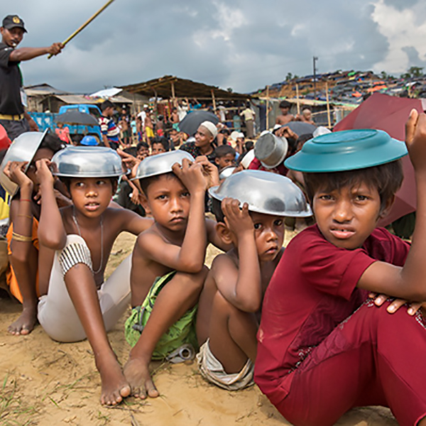 Rohingyan children sitting in a food line