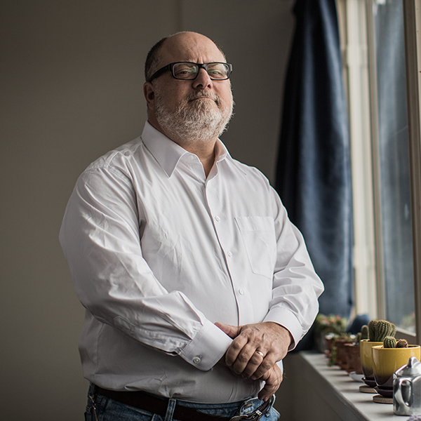 Adam Kahane posing next to a window