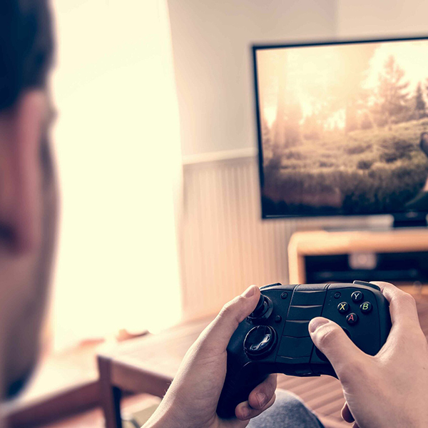 Person holding a game controller in front of a TV