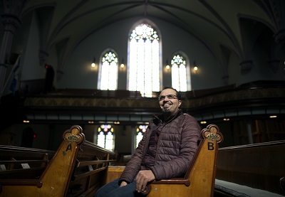 Anwar Alhjooj sitting in a church pew