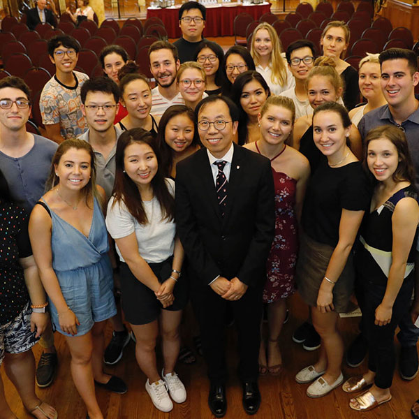 Peter Fu surrounded by smiling students