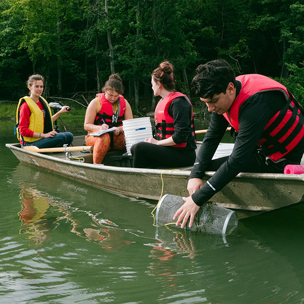 4 researchers sitting in a boat in a lake