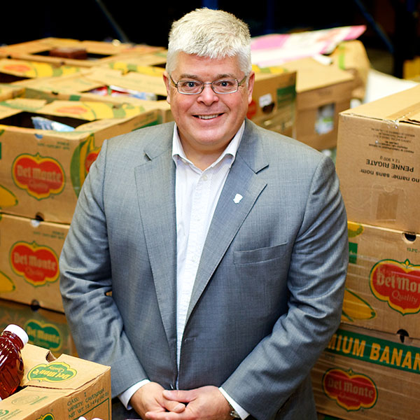 Richard Daneau smiling in front of food pallets