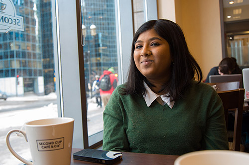 Neha Rahman sitting in a cafe, smiling