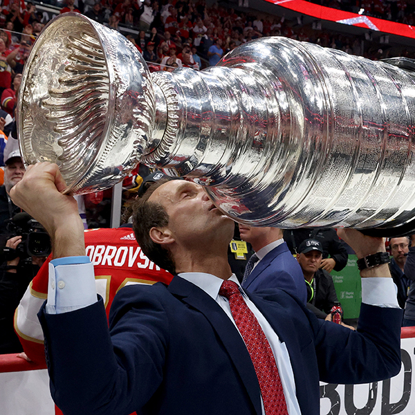 A person in a suit holding the Stanley Cup