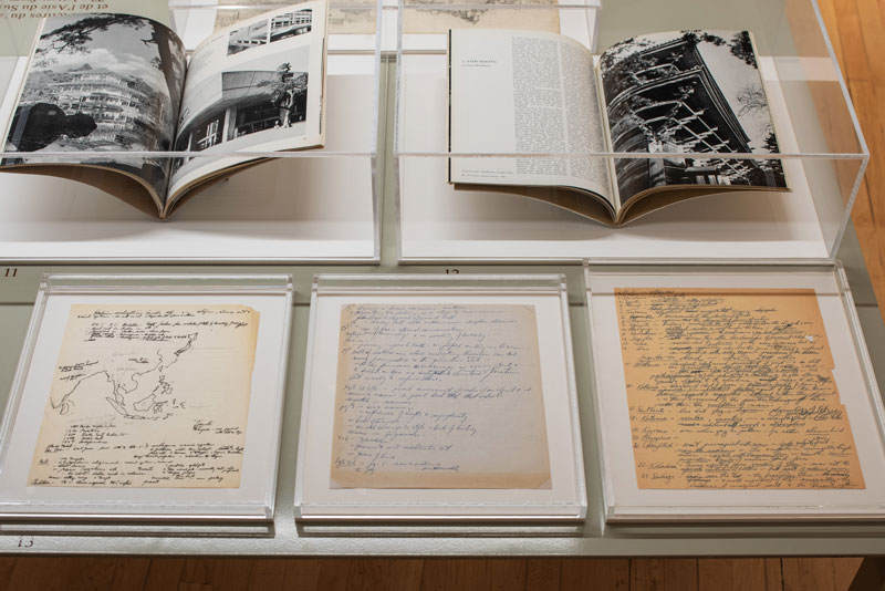 A collection of handwritten notes under a glass case.