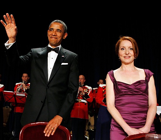 A person in a tuxedo waving at others and a person in purple dress