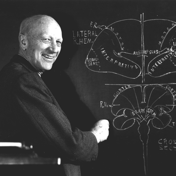 A man standing next to a blackboard.