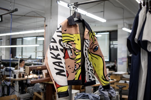 A jacket with graphic art on a rack.