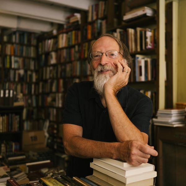 A man leaning on a stack of books.